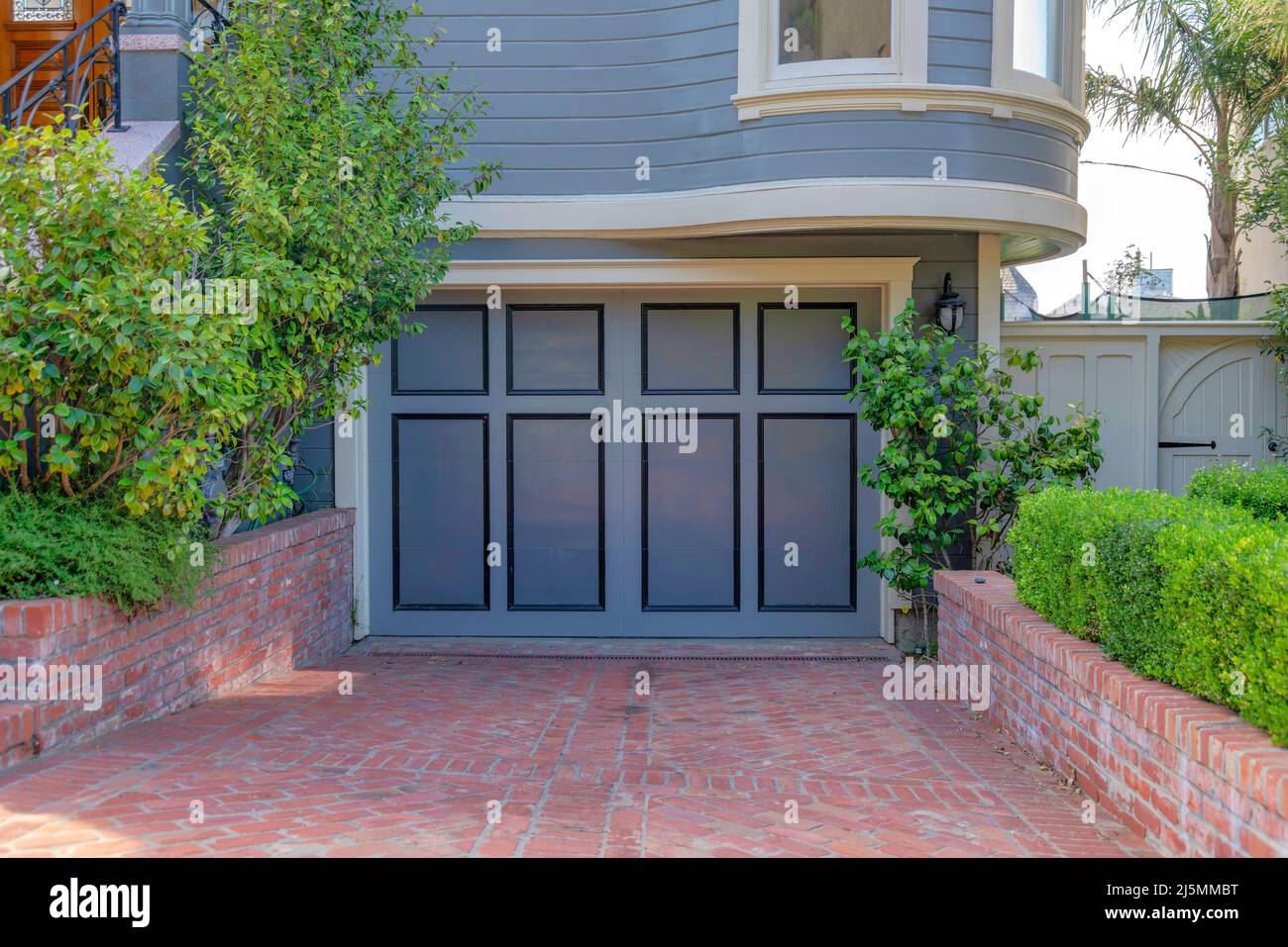 Garage exterior with side hinged doors and gray wall sidings at San