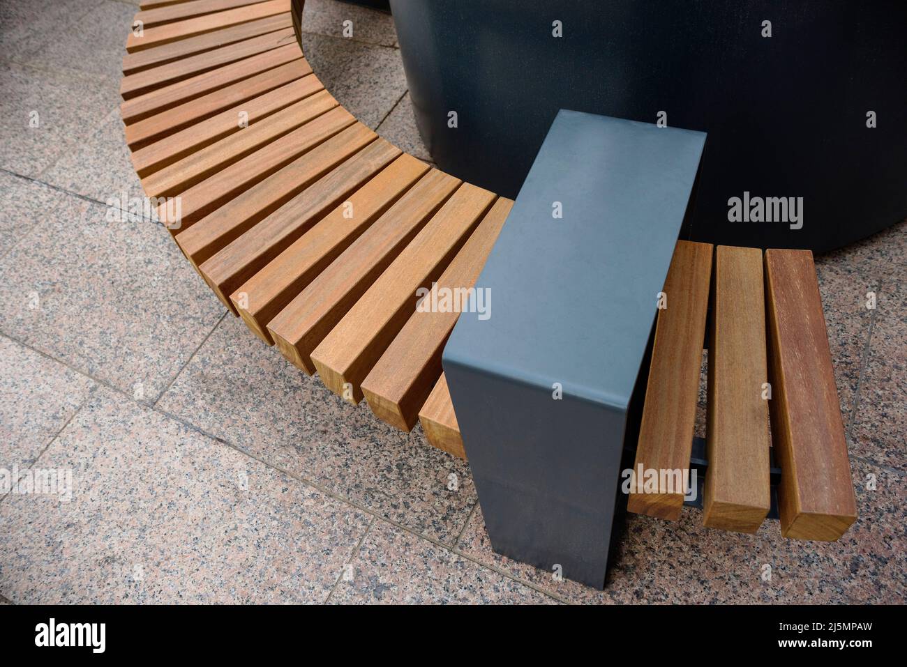 Durable hardwood bench public seating encourage socialising during office lunch breaks. Stock Photo