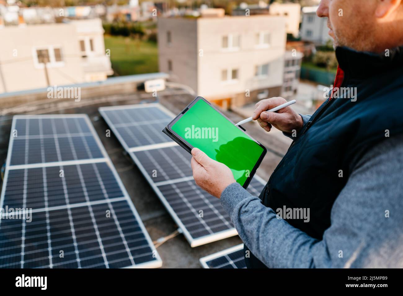 Worker installing solar energy systems. Using application. Tablet with green screen. Eco concept alternative energy Stock Photo
