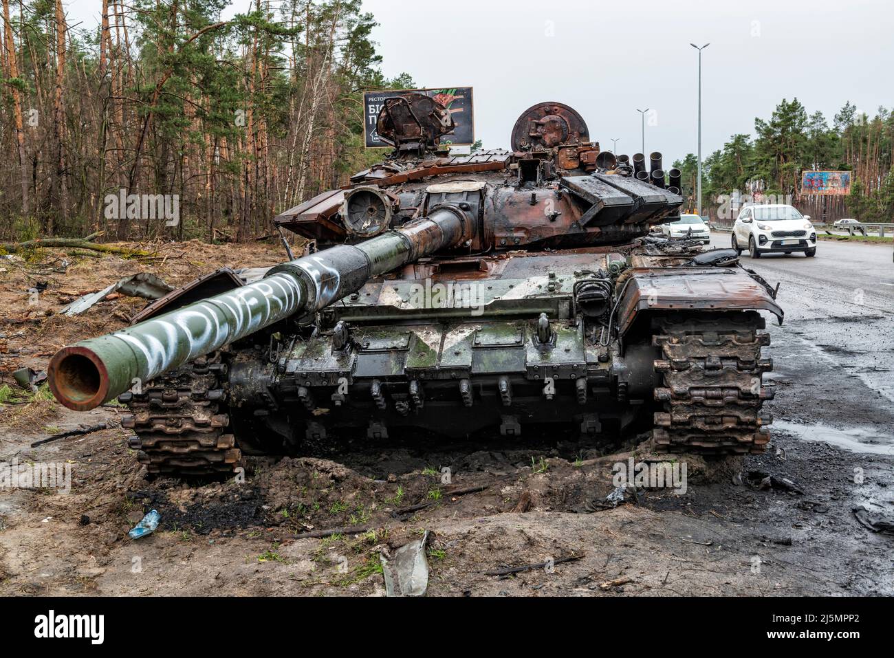 2022-04-09 Kyiv region, Ukraine. Destroyed russian tank with Wolverines painting stucked in the mud on the E40 highway near Kyiv. War in Ukraine Stock Photo