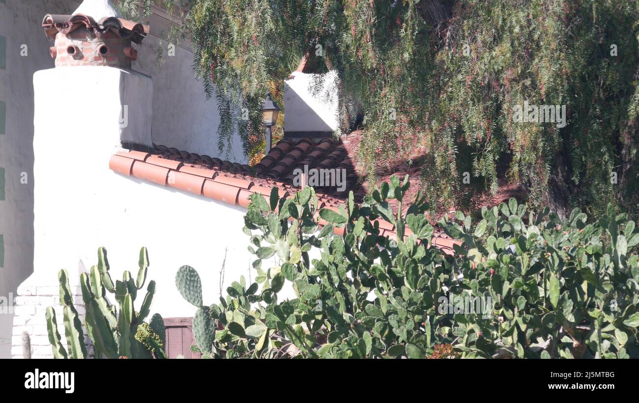 Roof of old house tiled, terracotta ceramic clay tiles. Mexican or spanish colonial mediterranean style, rural garden. Provincial village, countryside rustic ranch in greenery. Suburban California. Stock Photo