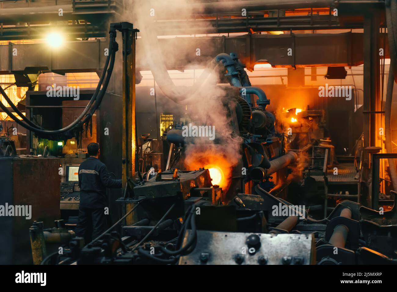 Metal casting in metallurgical plant or factory. Process of melting and forming production of iron pipes in industrial machines in workshop. Stock Photo