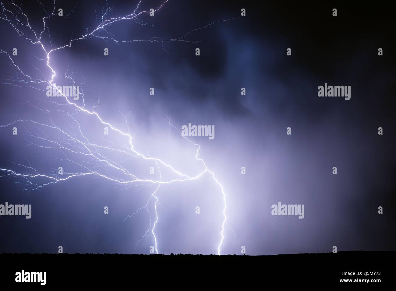 Flashes of lightning illuminate a thunderstorm in the night sky near Stinnett, Texas Stock Photo