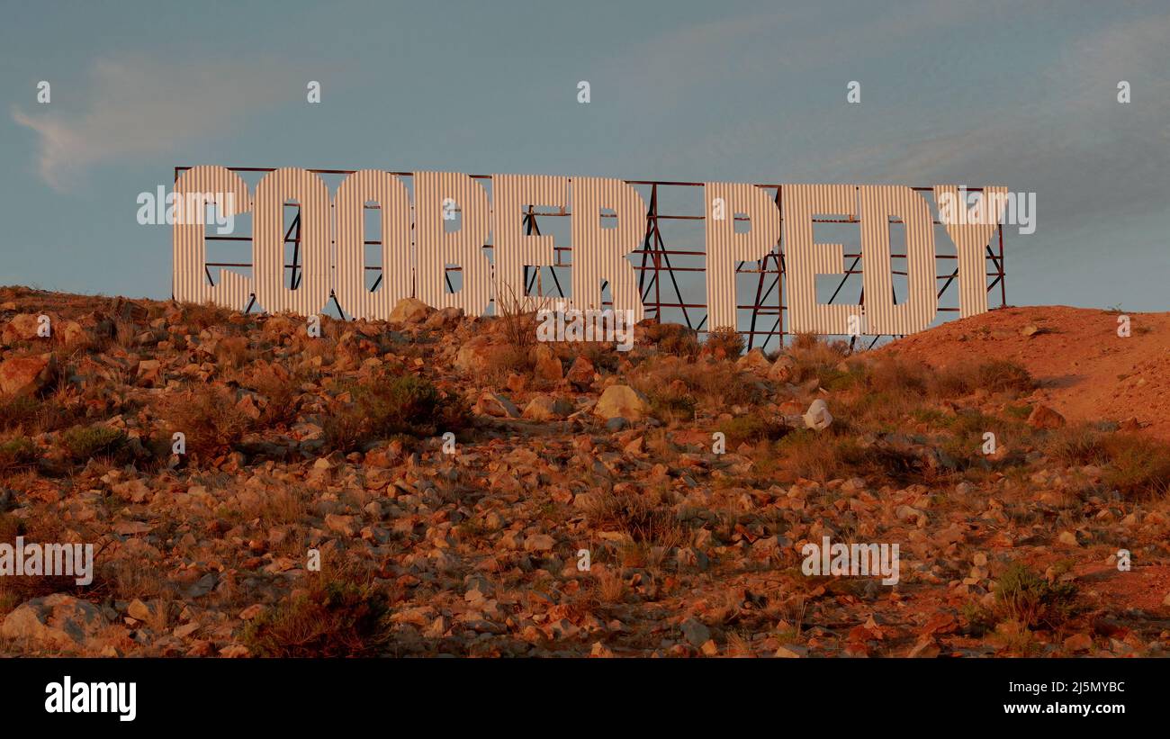 sunset shot of a large sign with the words coober pedy Stock Photo