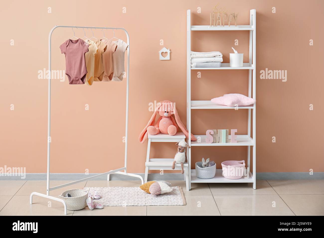 Interior of stylish children's room with rack, baby bodysuits and ...