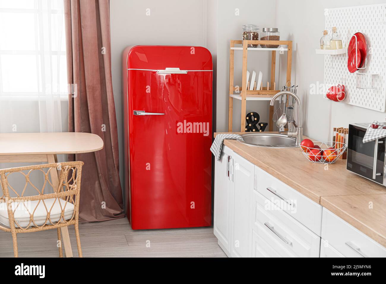Interior of light kitchen with retro fridge, white counters and ...