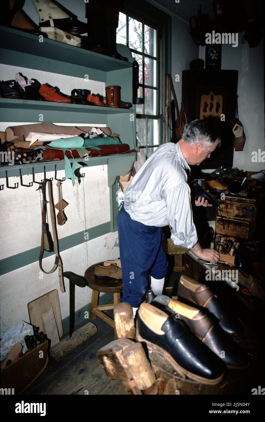 Williamsburg, CA. U.S.A. 9/1987. Cordwainer was the title given to shoemakers.  Cobblers were those who repaired shoes.  The cobbler had as much as five years less training than a cordwainer.  The American colonies, cobblers were prohibited by proclamation from making shoes.  The first shoemakers, tanners and other tradesmen arrived in Jamestown in 1607. among the colony’s principal founder John Smith’s many talents, was that of shoemaker –  the settlement was partially funded by a thriving English shoe trade. Stock Photo