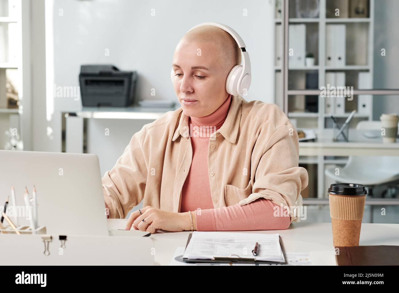 Content young office woman in wireless headphones listening to music ...