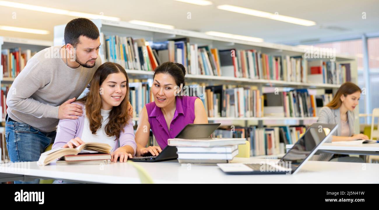 Female and male colleagues working together in public library Stock ...