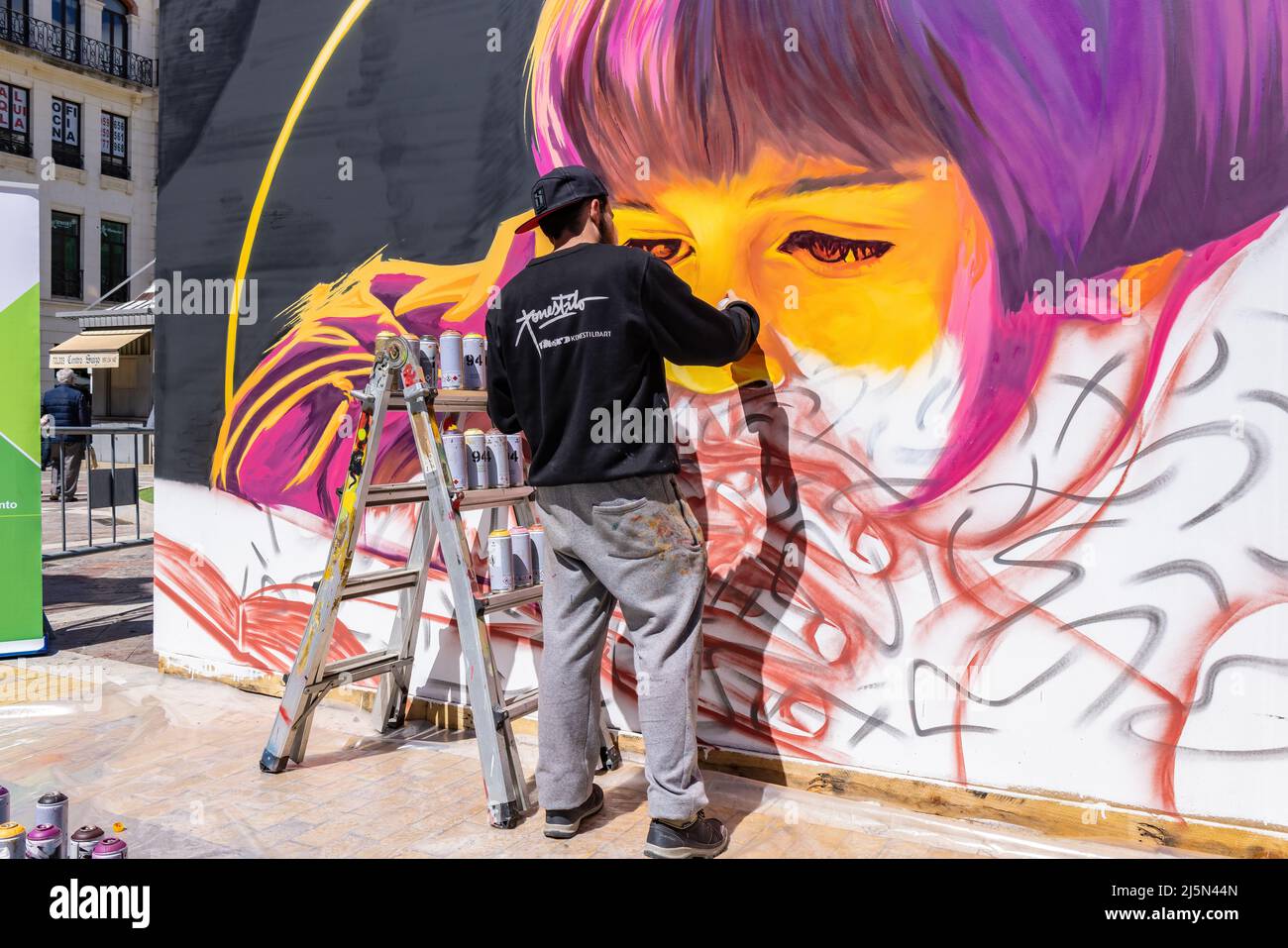 Huelva, Spain - April 24, 2022: The urban artist Victor Romero Konestilo is creating a workart in live of Graffiti, on the occasion of the Huelva book Stock Photo