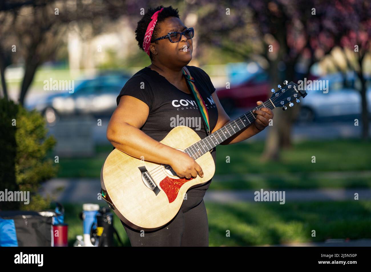 Paisha Thomas, a musical artist, sings and plays original songs on guitar at the Community Vigil of Ma'Khia Bryant marking one year since Ma'Khia Bryant was shot and killed by Columbus Police. A candlelight vigil and memorial was held for Ma'Khia Bryant at Mayme Moore Park in Columbus, Ohio one year after Bryant was shot and killed by Columbus Police at the age of 16 years old on Saturday April 23, 2022. Ma'Khia Bryant's sisters Azariah Bryant, 14, and Ja'Niah Bryant, 16, appeared along with their grandmother, Jeanene Hammonds, and their aunt, Myra Duke. Stock Photo