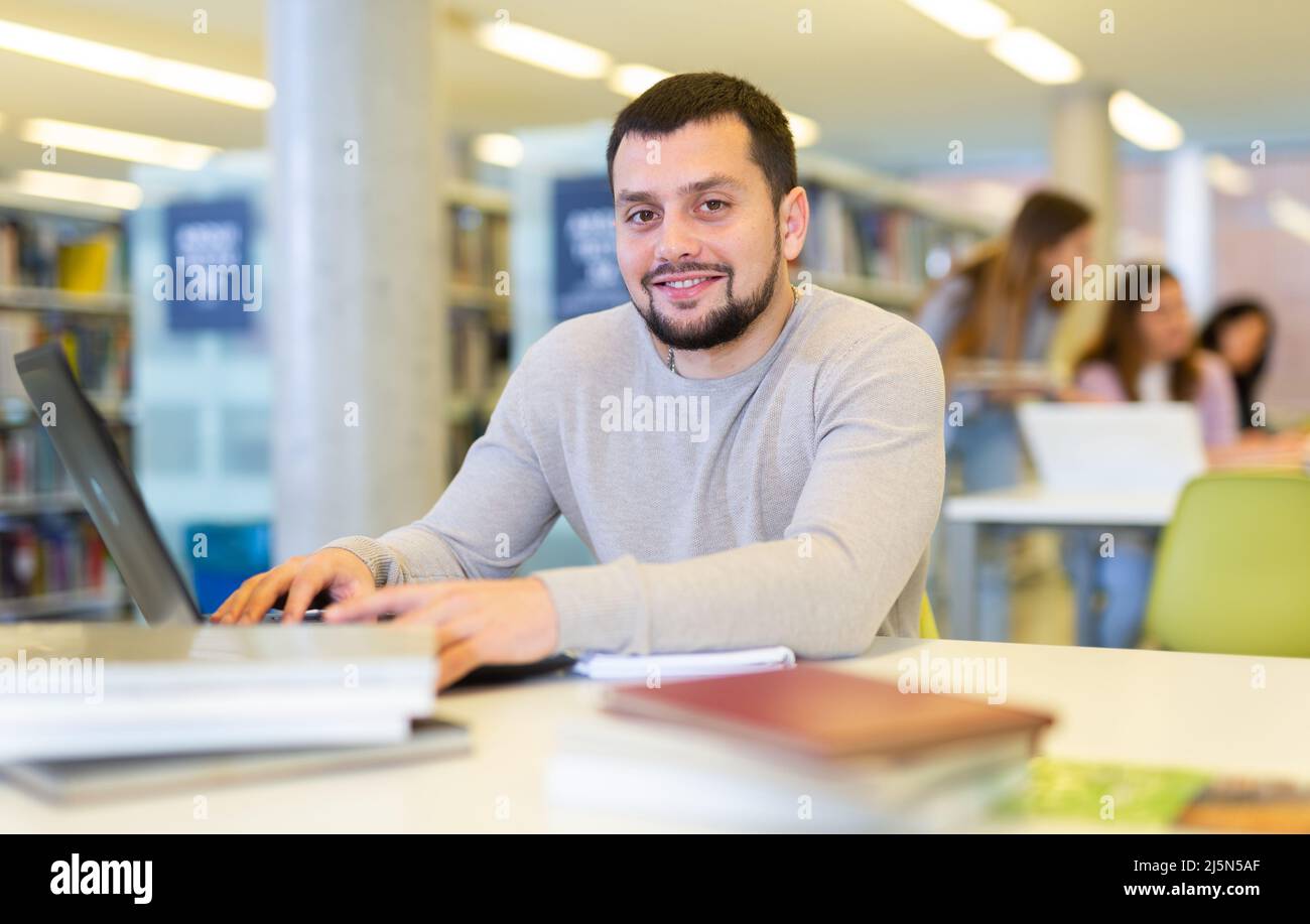 Portrait of man working at a computer in public library Stock Photo - Alamy