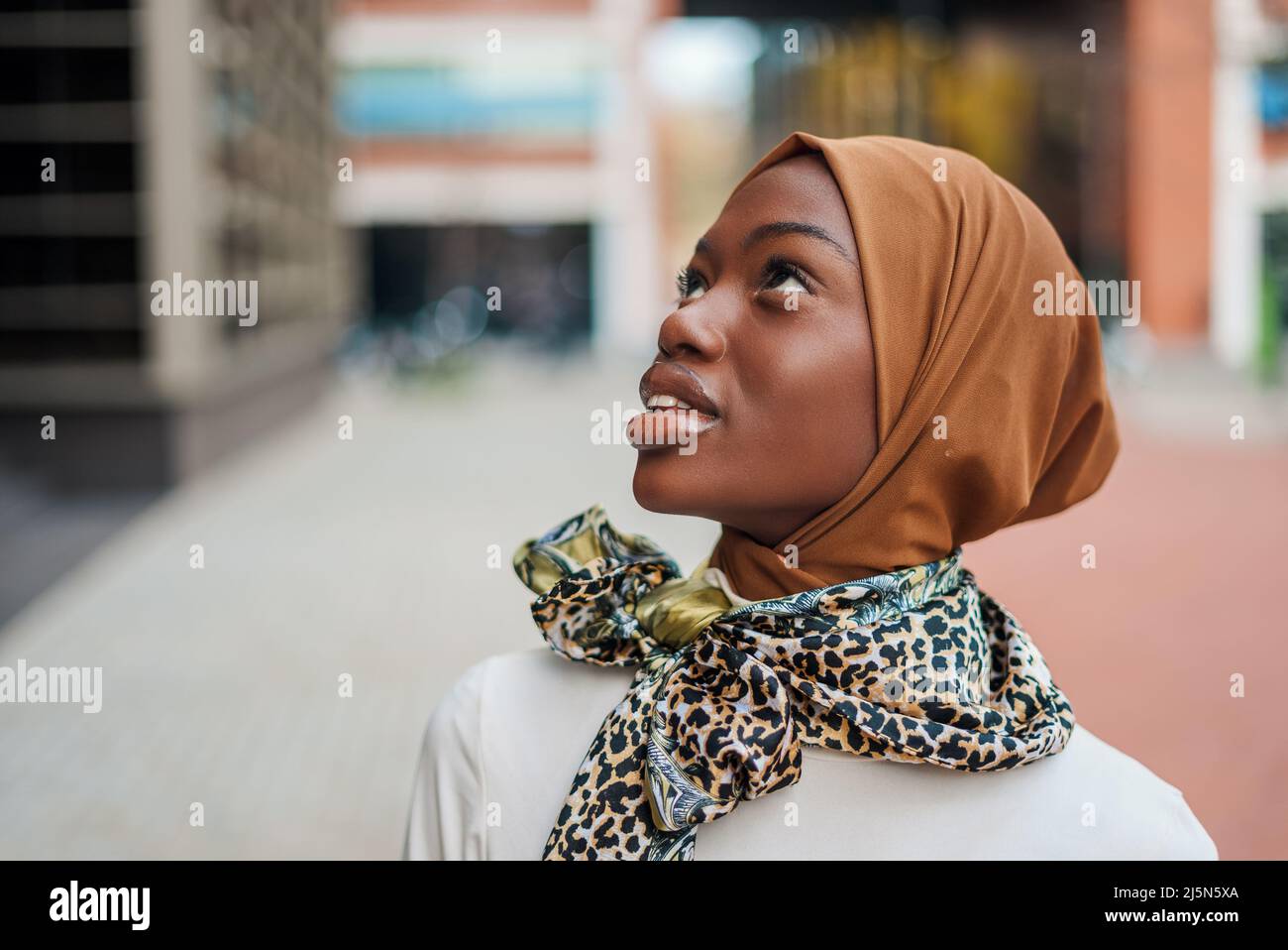Young Muslim black woman in hijab looking up Stock Photo