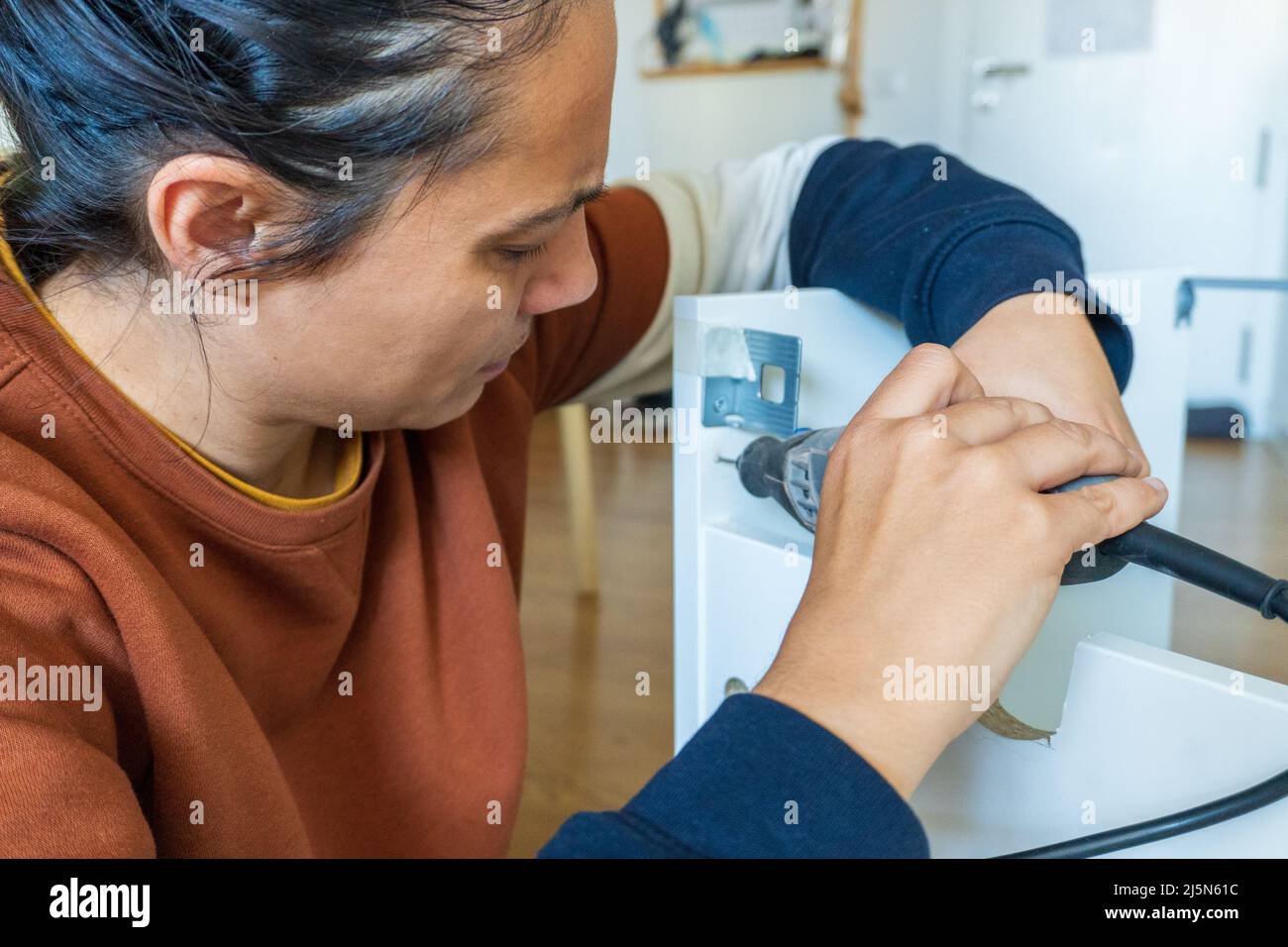 woman using mini drill and doing bricolage Stock Photo