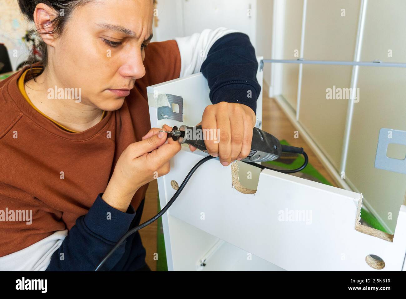 woman using mini drill and doing bricolage Stock Photo
