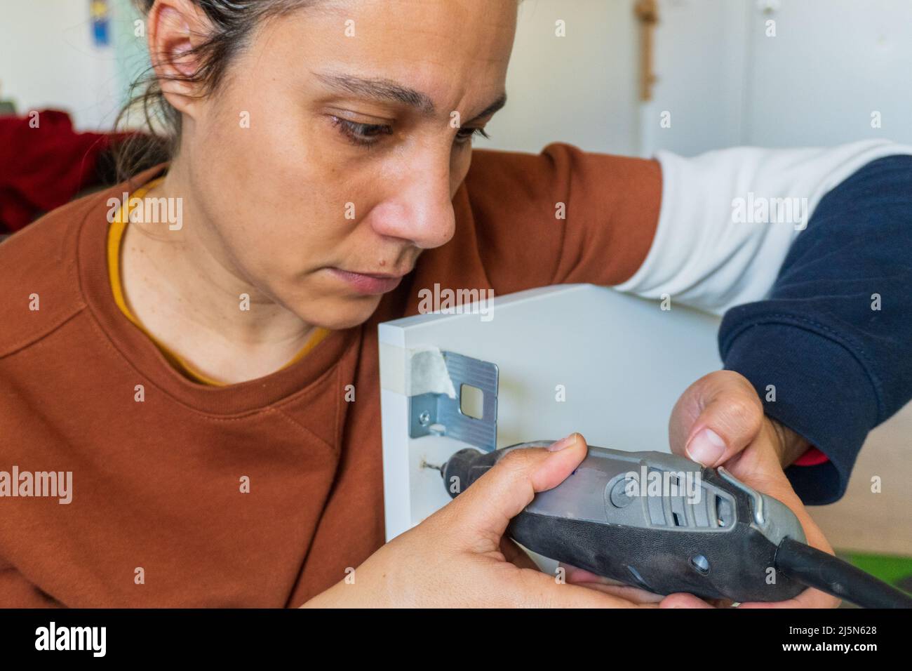 woman using mini drill and doing bricolage Stock Photo