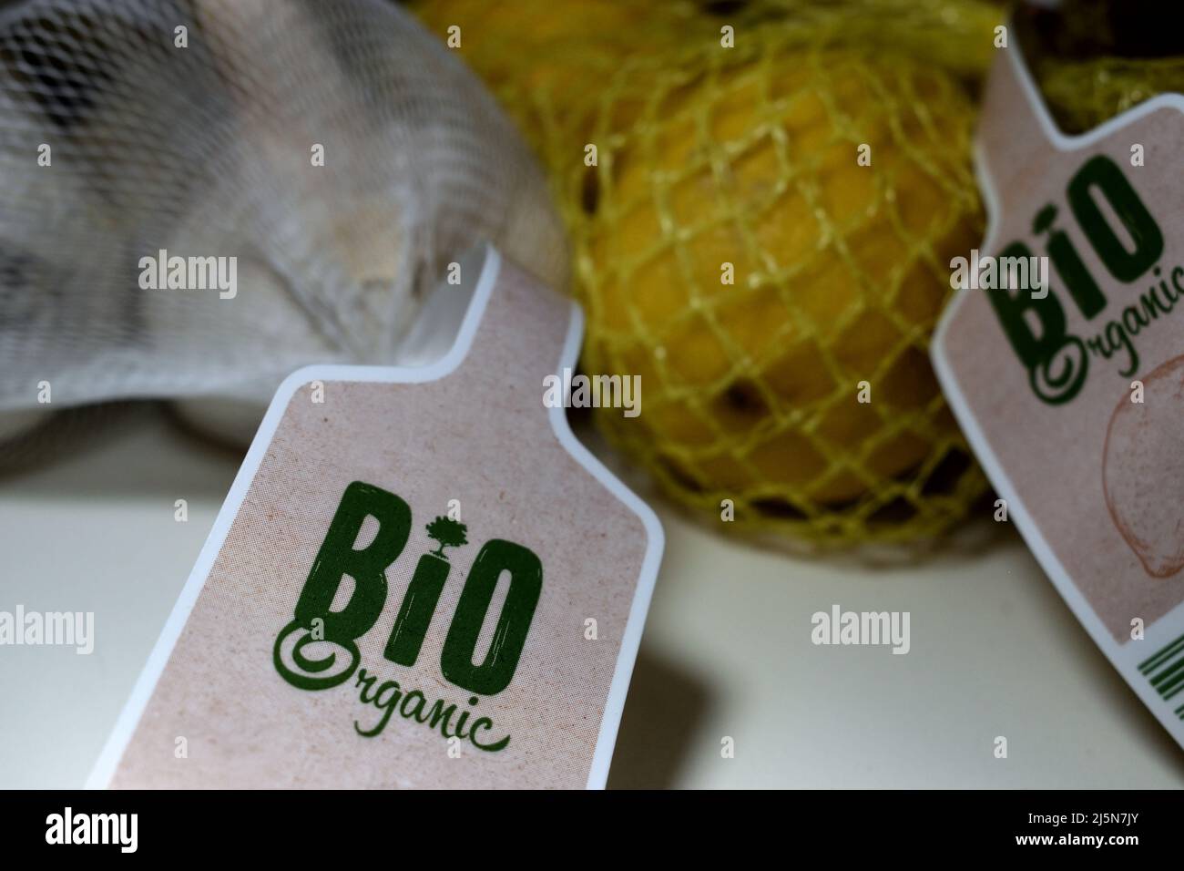 Bio organic garlic and yellow lemons in a fruit net with a label ...