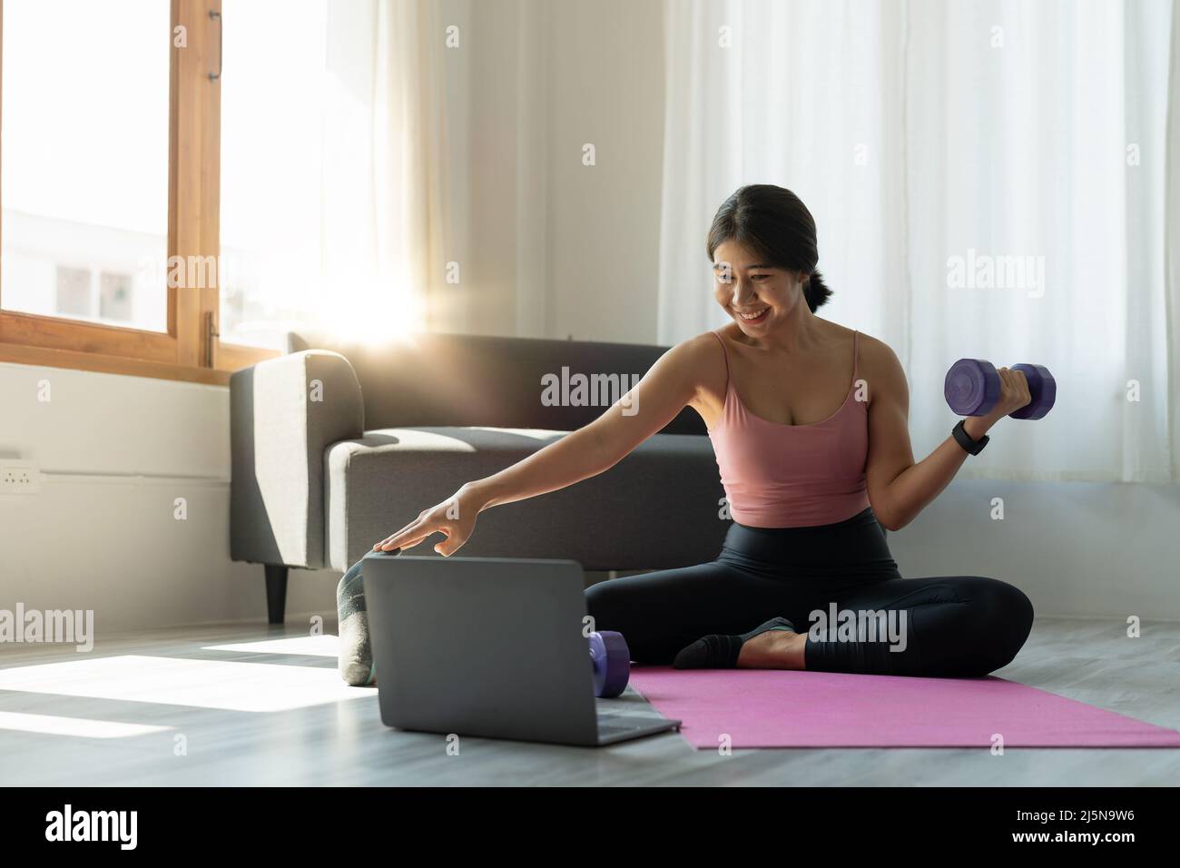 Young woman is exercising yoga at home. Fitness, workout, healthy living and diet concept Stock Photo