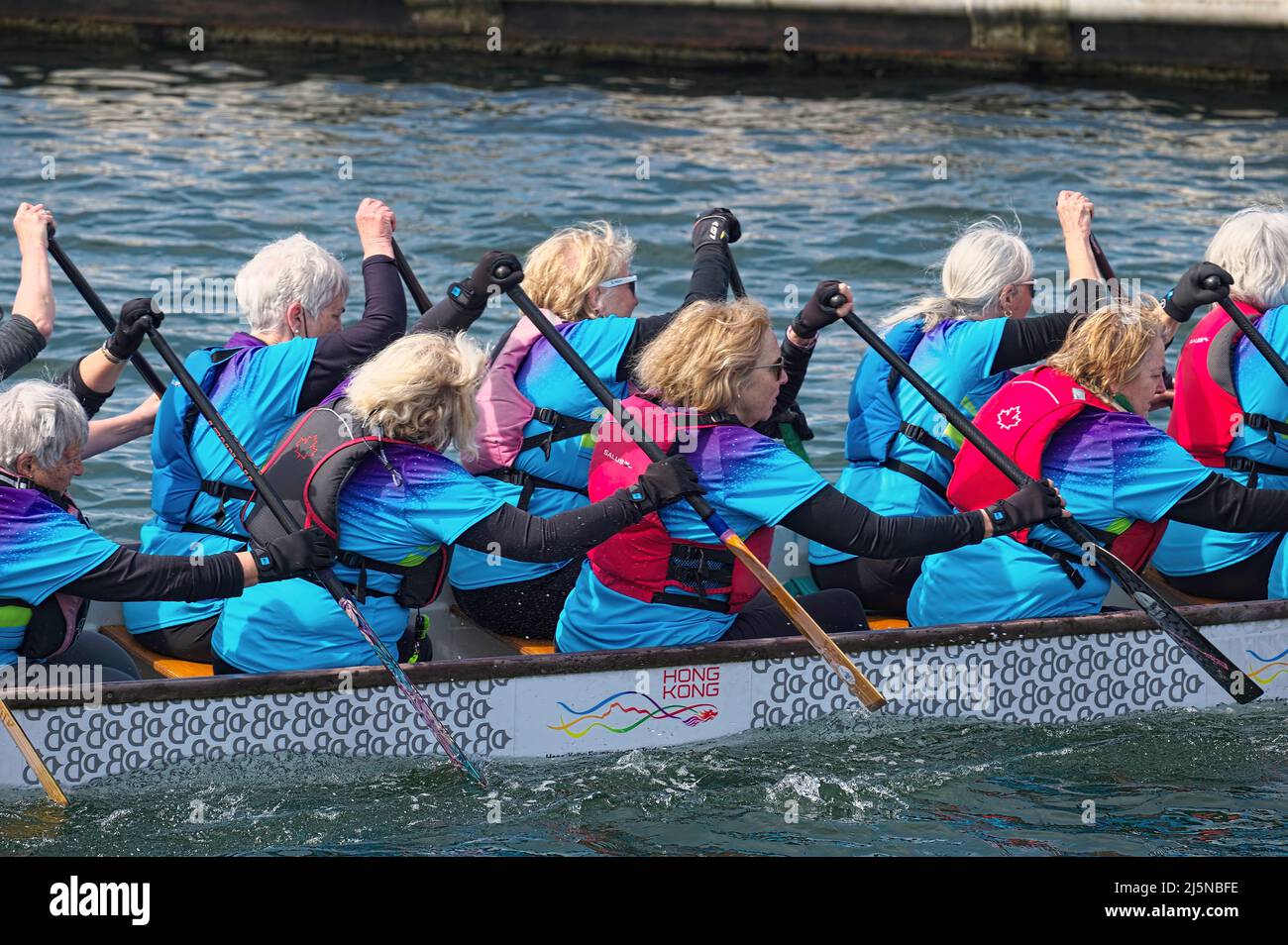 Women competitors in a dragon boat race in the Inlet Spring Regatta 2022 at Rocky Point Park, Port Moody, B. C., Canada. April 23, 2022. Stock Photo