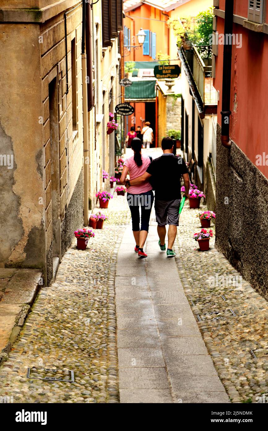 Couple walking down a cobbled street in Bellagio on the shores of Lake Como in northern Italy Stock Photo