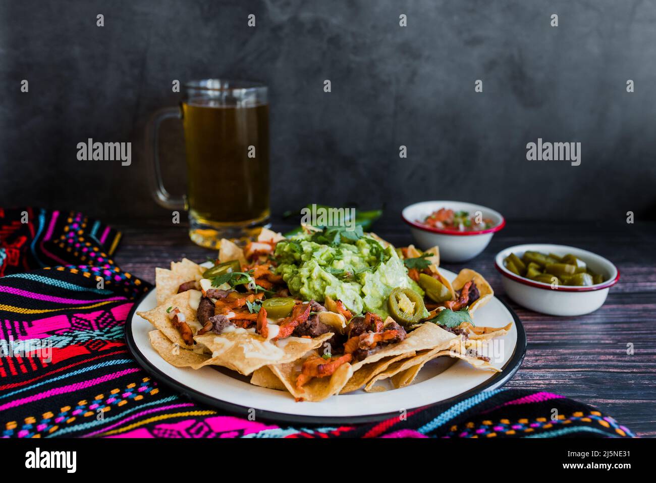 Mexican nachos chips with american cheese and avocado, traditional food