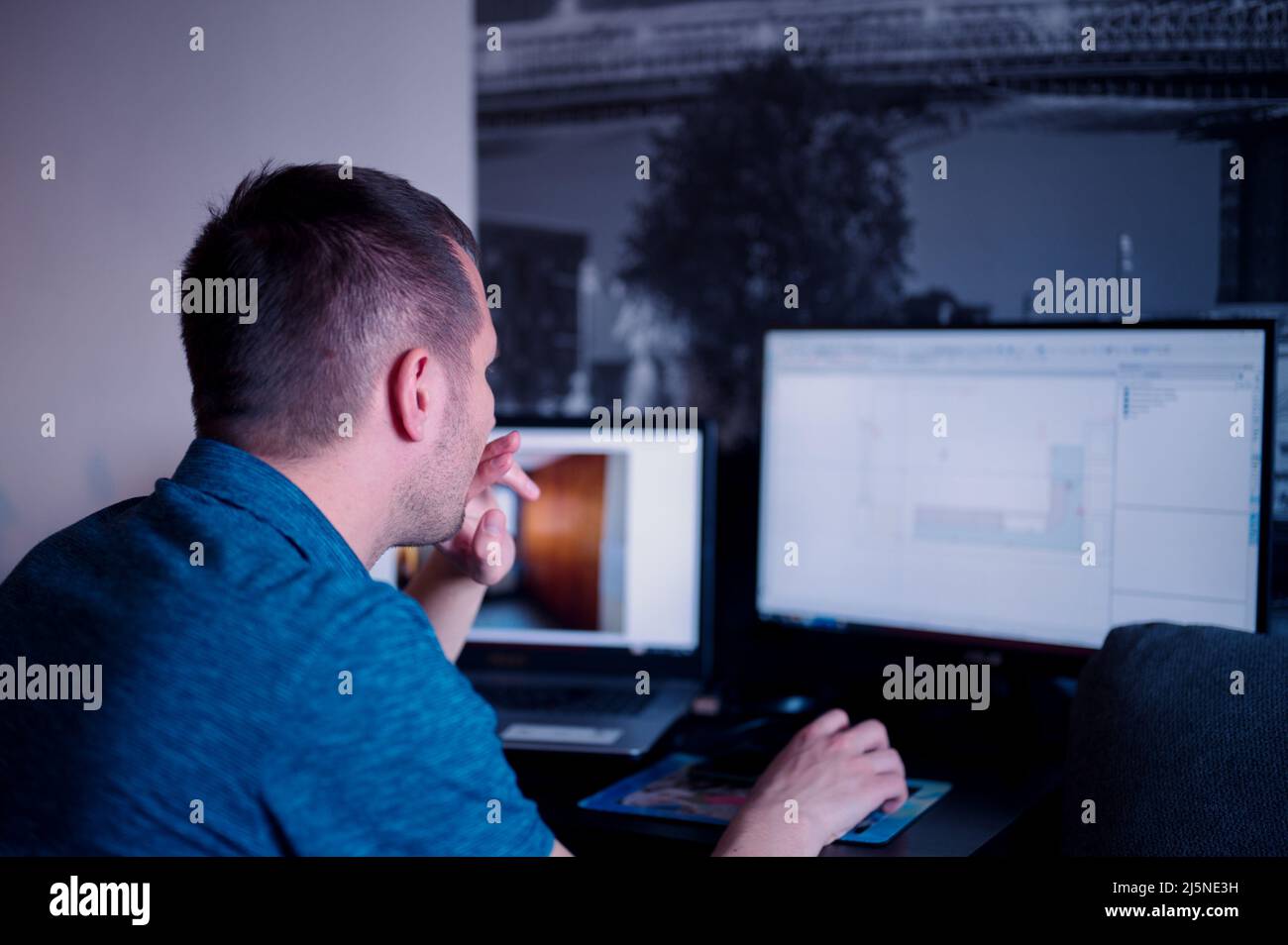 Mature man sitting at the table using computer for business Stock Photo