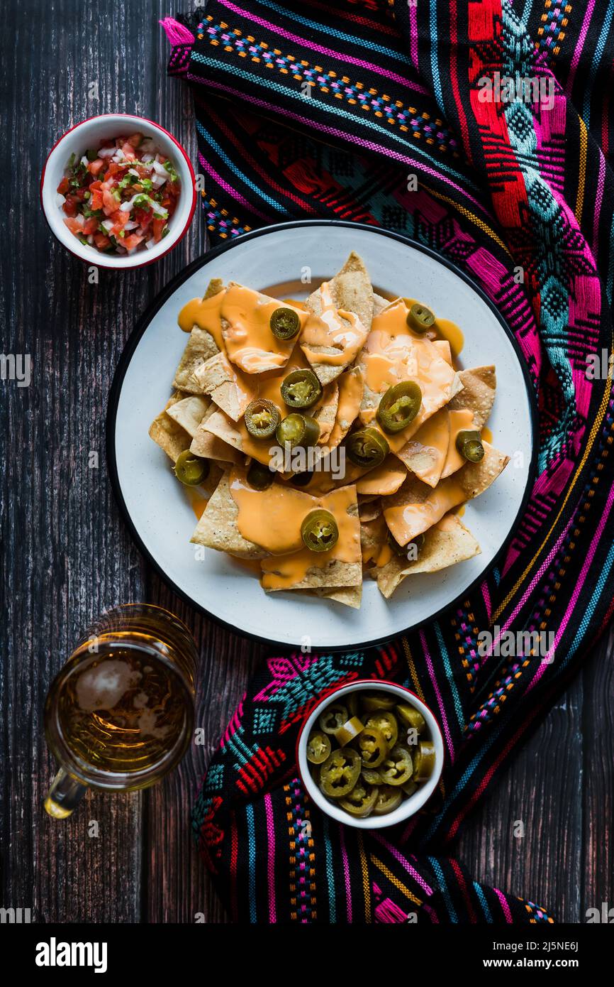 Mexican nachos chips with american cheese, beer and jalapeños in Mexico Latin America Stock Photo