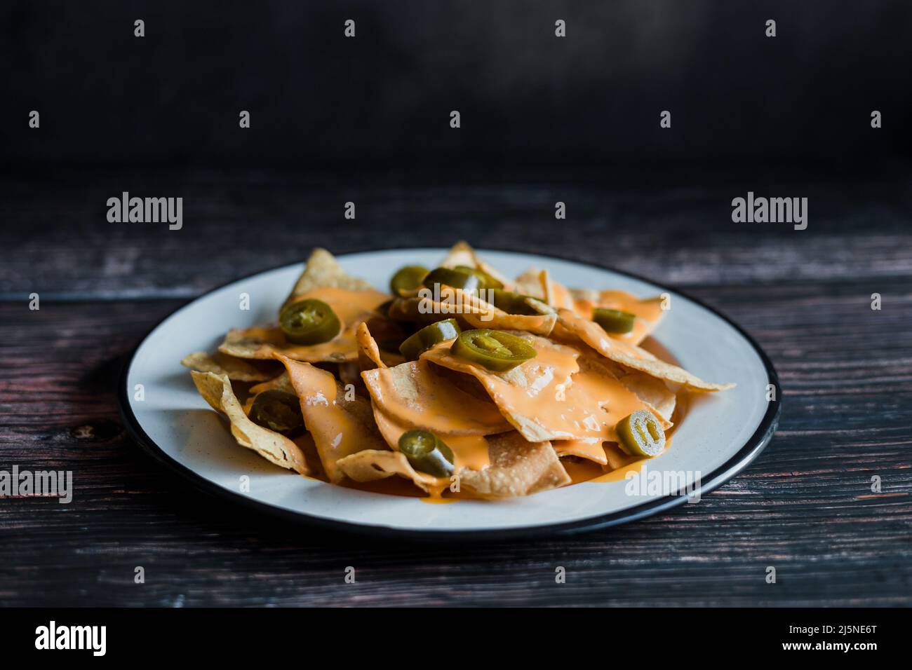 Mexican nachos chips with american cheese, beer and jalapeños in Mexico Latin America Stock