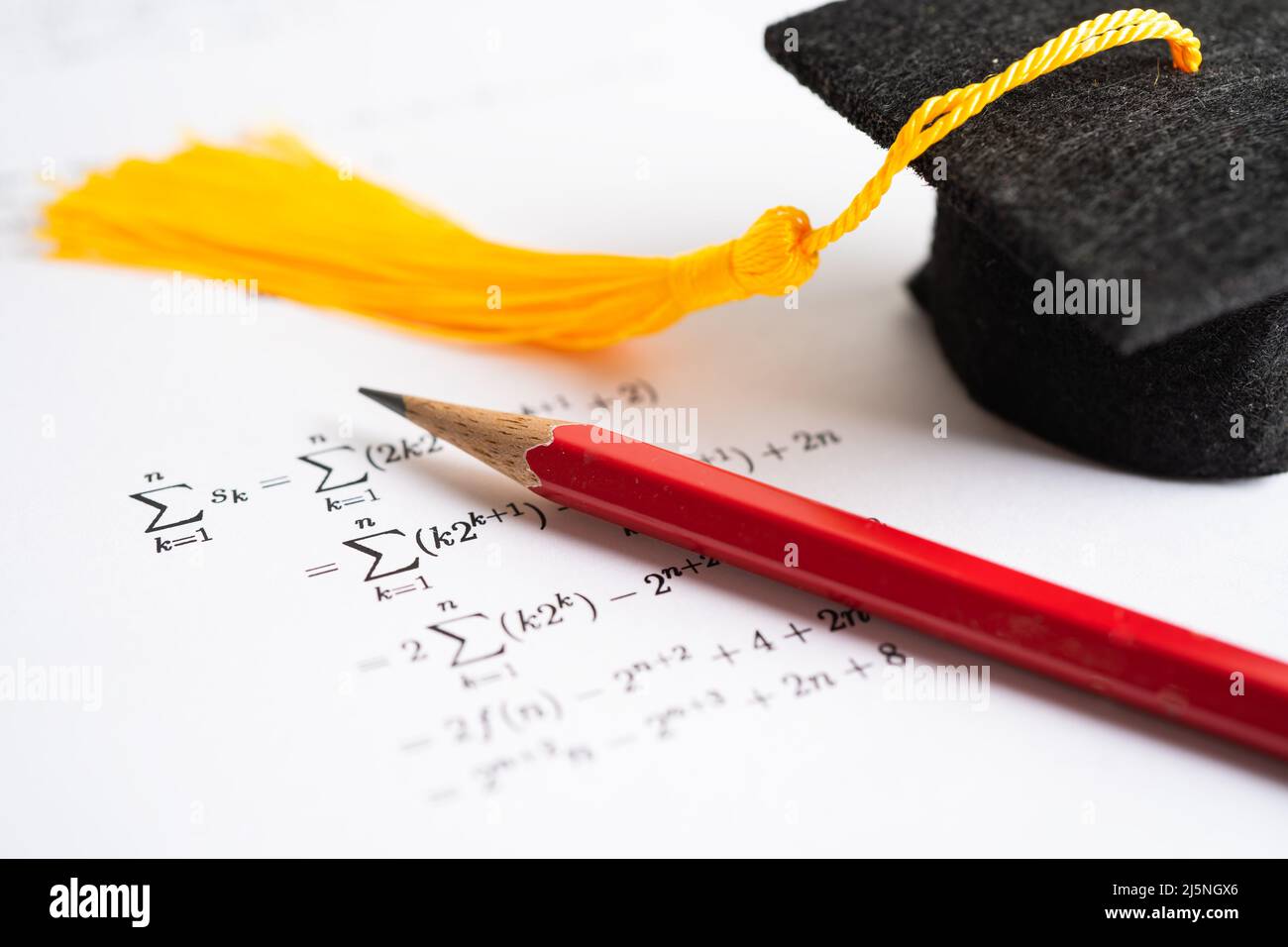 Graduation gap hat and pencil on mathematic formula exercise test paper in education school. Stock Photo