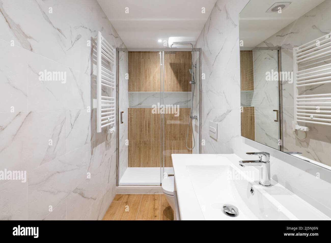 Interior of modern refurbished bathroom with shower and wooden