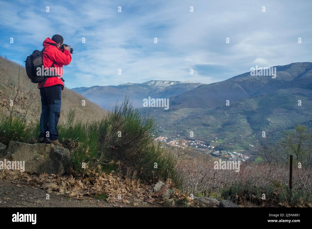 Trekker man taking picture to Jerte Valley on winter. Navaconcejo, Caceres, Extremadura, Spain Stock Photo