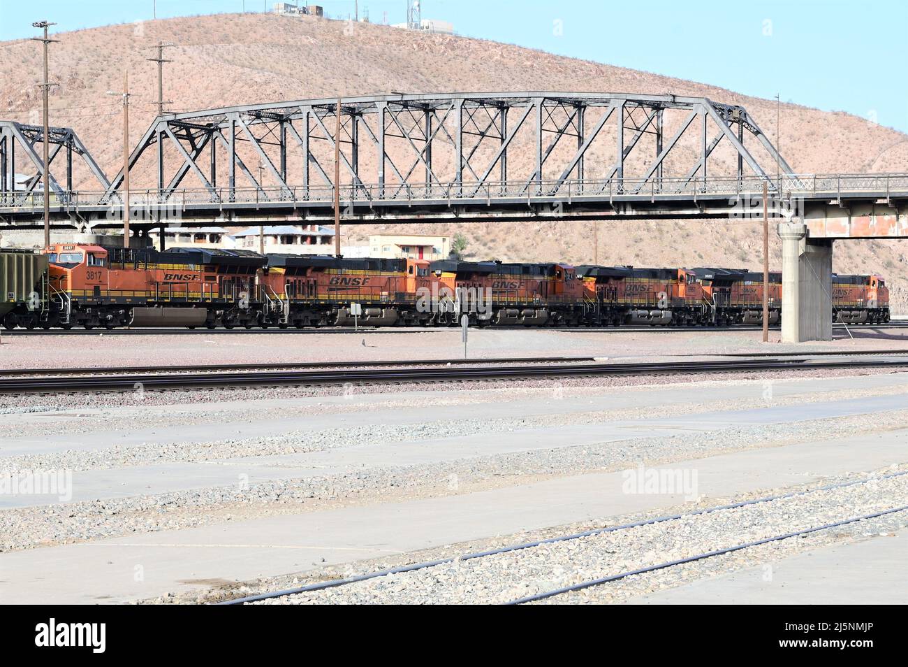 BNSF 7780 BNSF Railway GE ES44DC locomotive passing through Barstow station with a freight train. Stock Photo