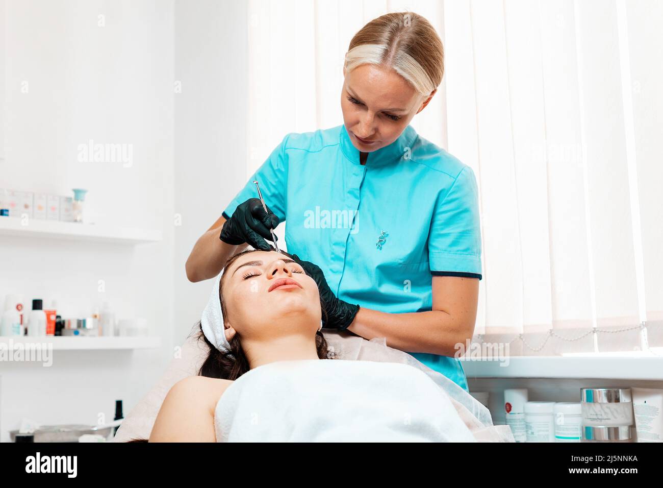 Cosmetologist doing acne treatment using mechanical steel instrument