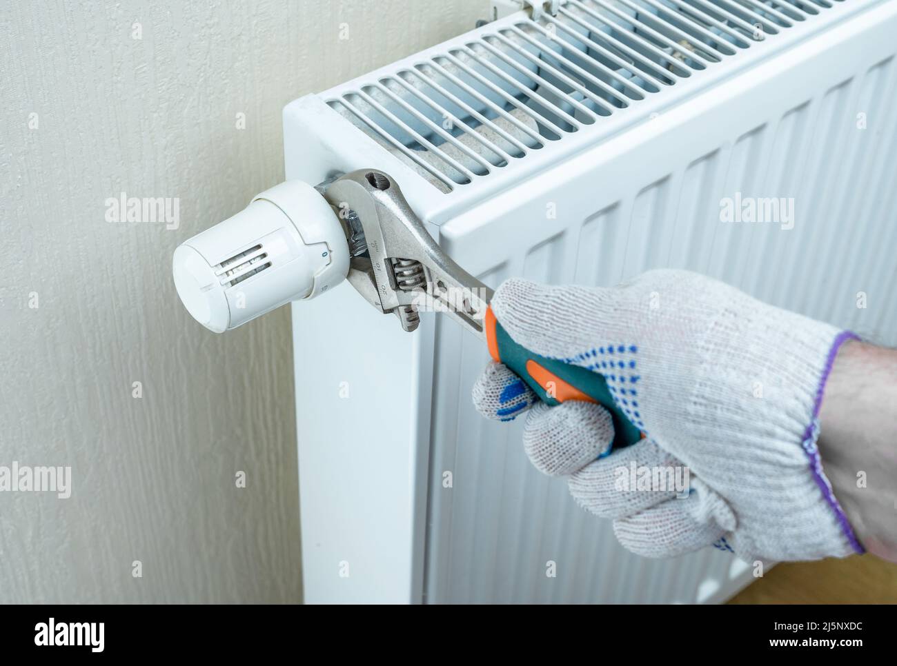 saving energy resources. hand with an adjustable wrench regulates heat