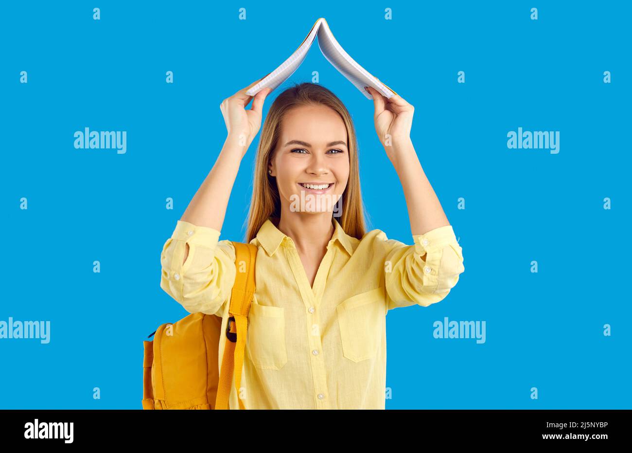 Smiling girl student with book and backpack Stock Photo - Alamy