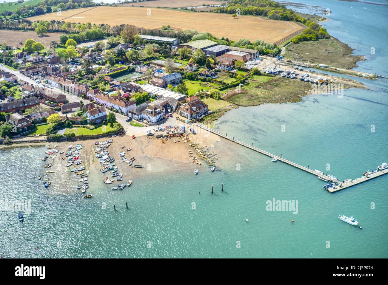 Itchenor sailing destination in Chichester Harbour with beautiful reflections from the water of the estuary. Aerial photo. Stock Photo
