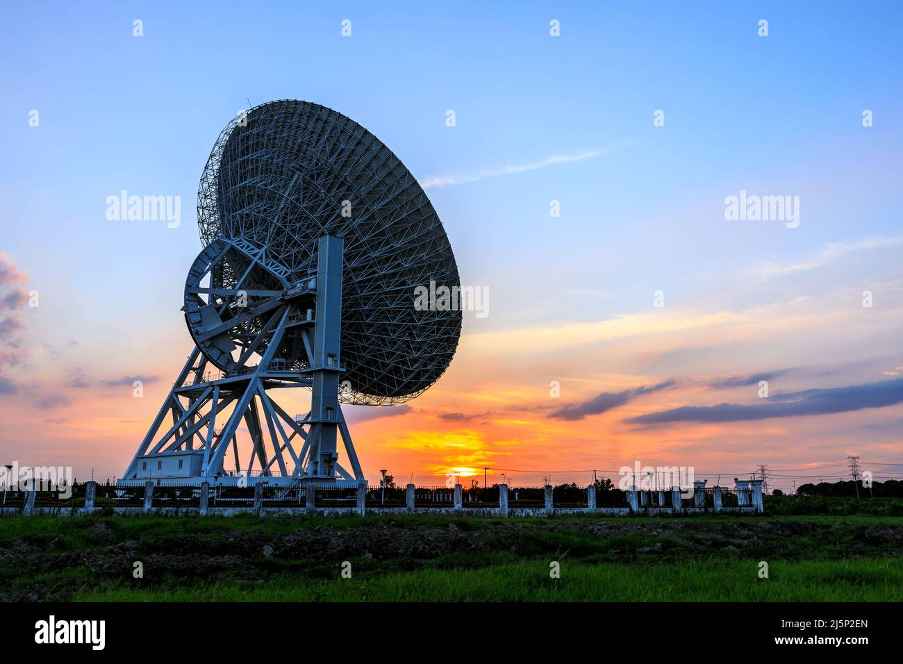 Astronomical radio telescope and beautiful sky clouds at sunset Stock Photo