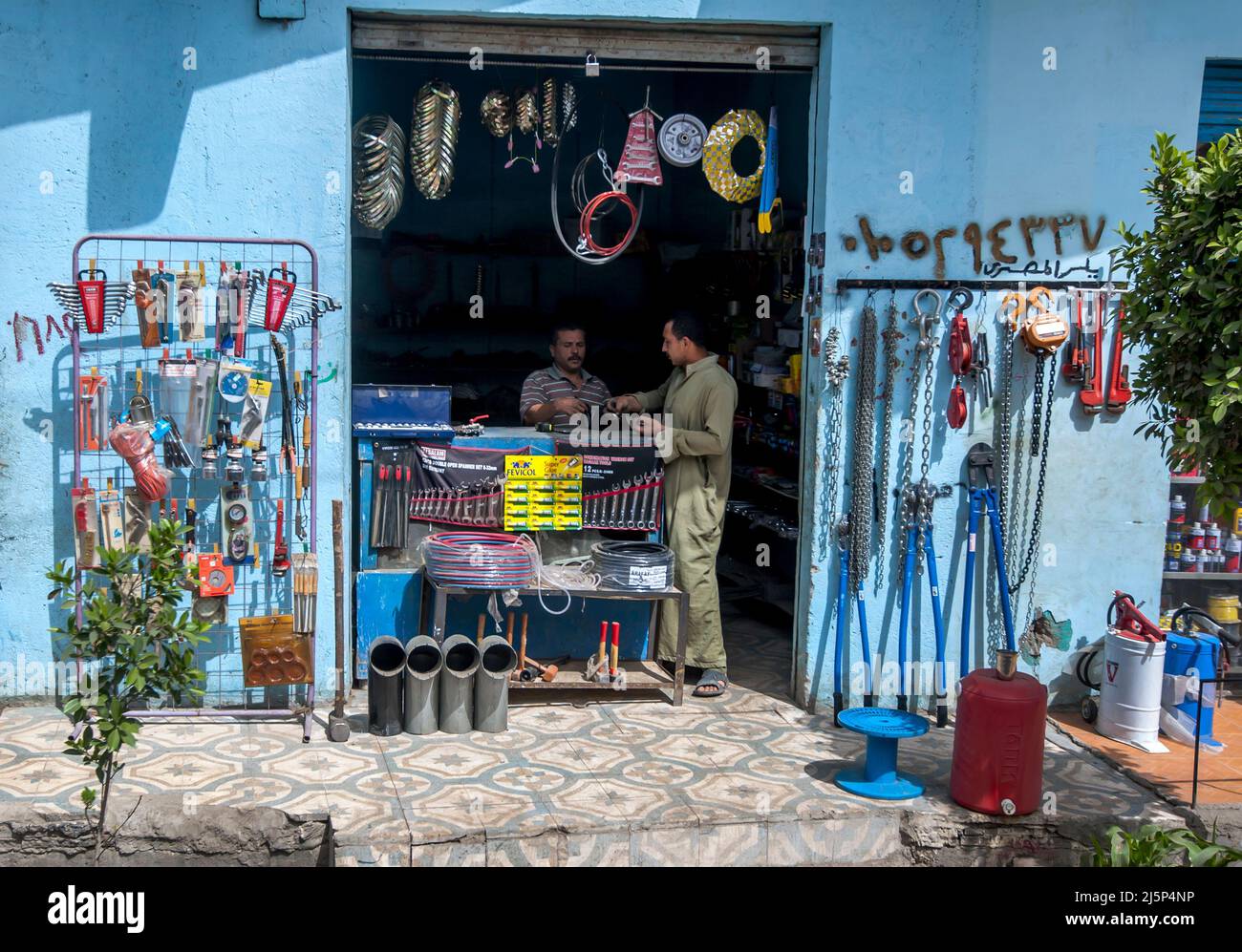 A hardware store owner serves a customer at his business on the outskirts of Cairo in Egypt. Stock Photo