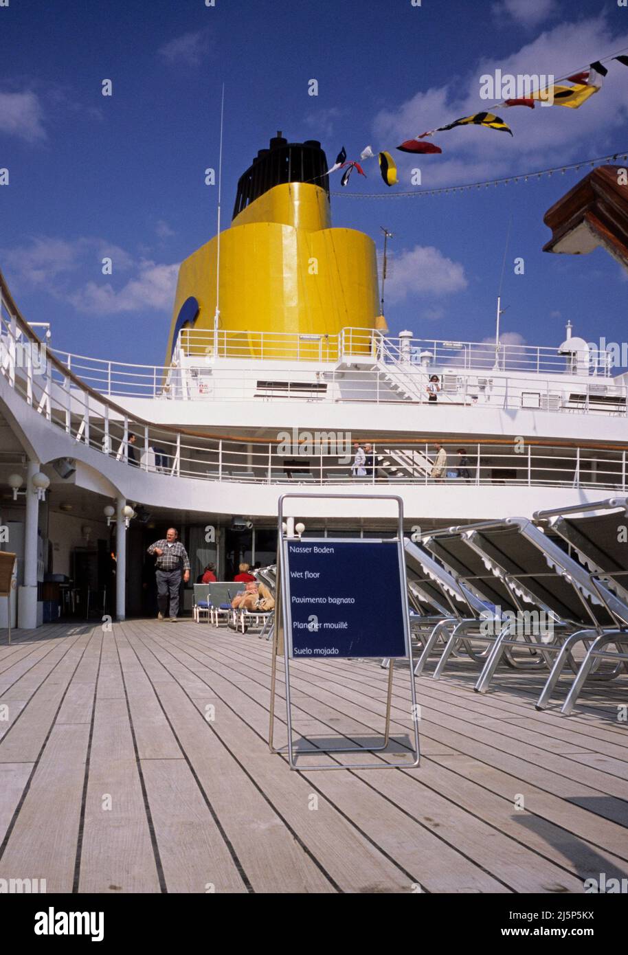 wet floor sign on pool deck of a cruise ship Stock Photo