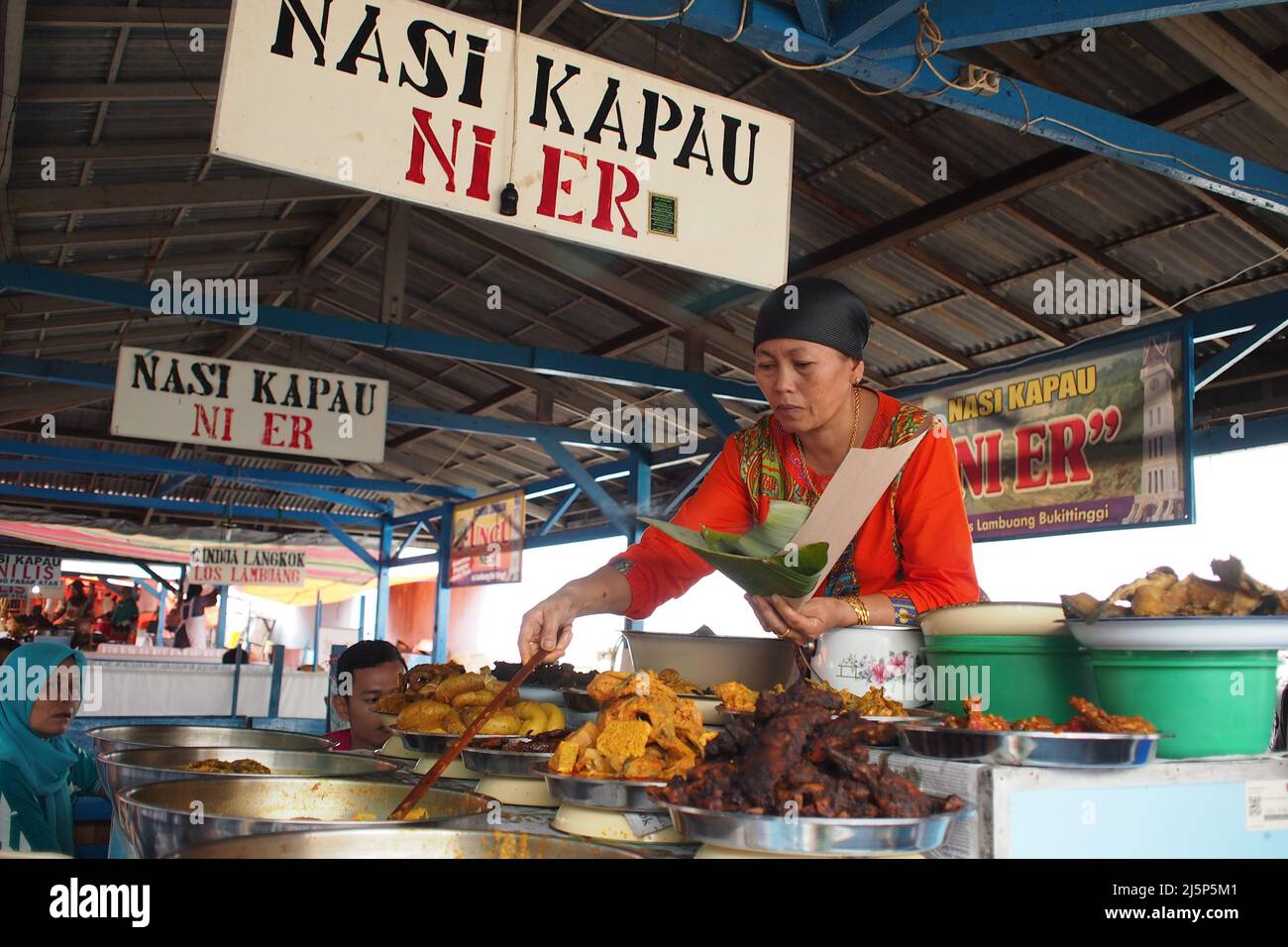 Kapau (name of an area in West Sumatra) rice traders are preparing dishes for buyers. Ni or Uni means sister in the local language, Er is her name Stock Photo