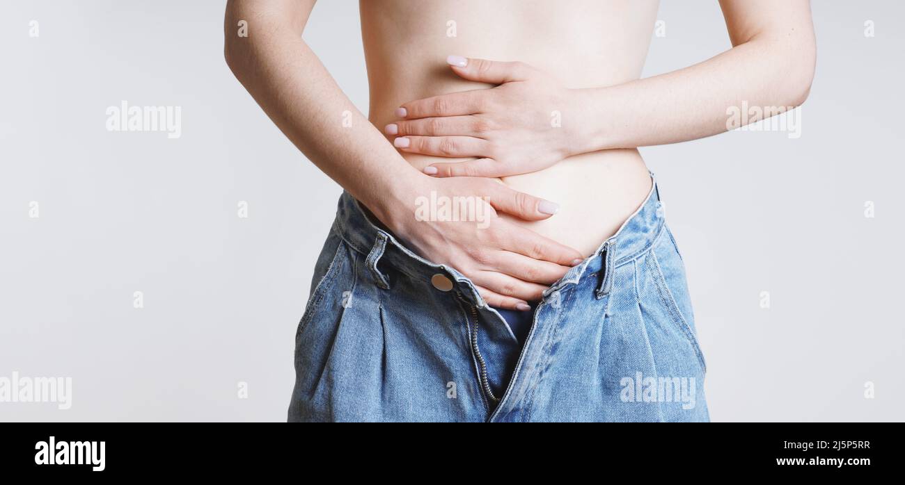 woman holding stomach with bellyache or period pains or indegestion Stock Photo