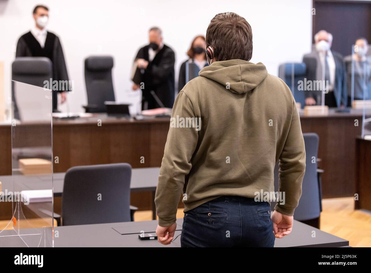 Nuremberg, Germany. 25th Apr, 2022. An accused man stands in the courtroom of the Criminal Justice Center of the Nuremberg-Fürth Regional Court as the trial begins. The prosecution accuses the 30-year-old man of attempted murder and dangerous bodily harm. In September 2021, due to delusions, he had knocked a sleeping 20-year-old man to the ground and kicked him several times in the head. Credit: Daniel Karmann/dpa/Alamy Live News Stock Photo