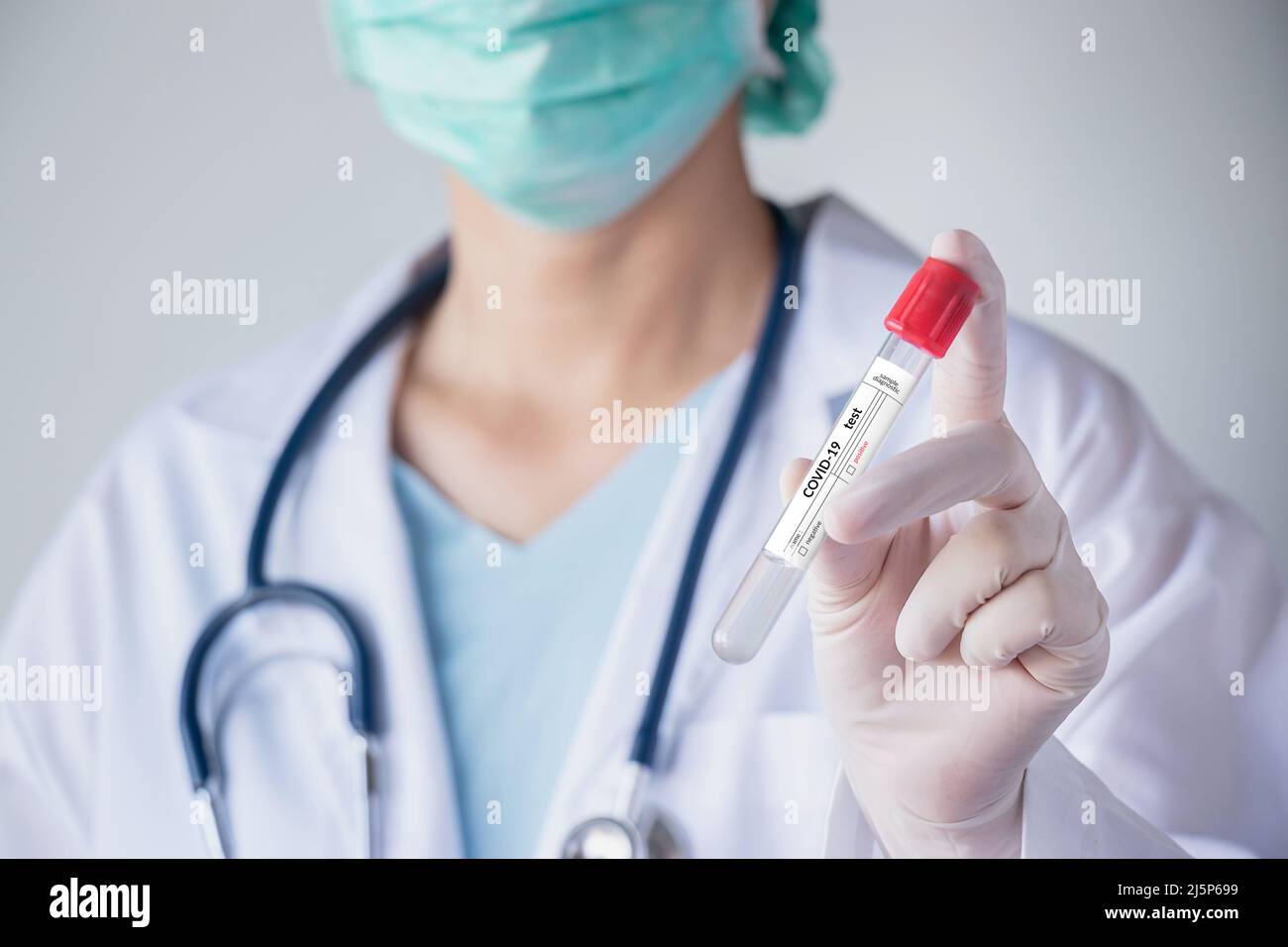 coronavirus COVID-19 test concept. doctor with hygienic mask, hand with glove holding test tube with patient nasal secretion sample for corona virus Stock Photo