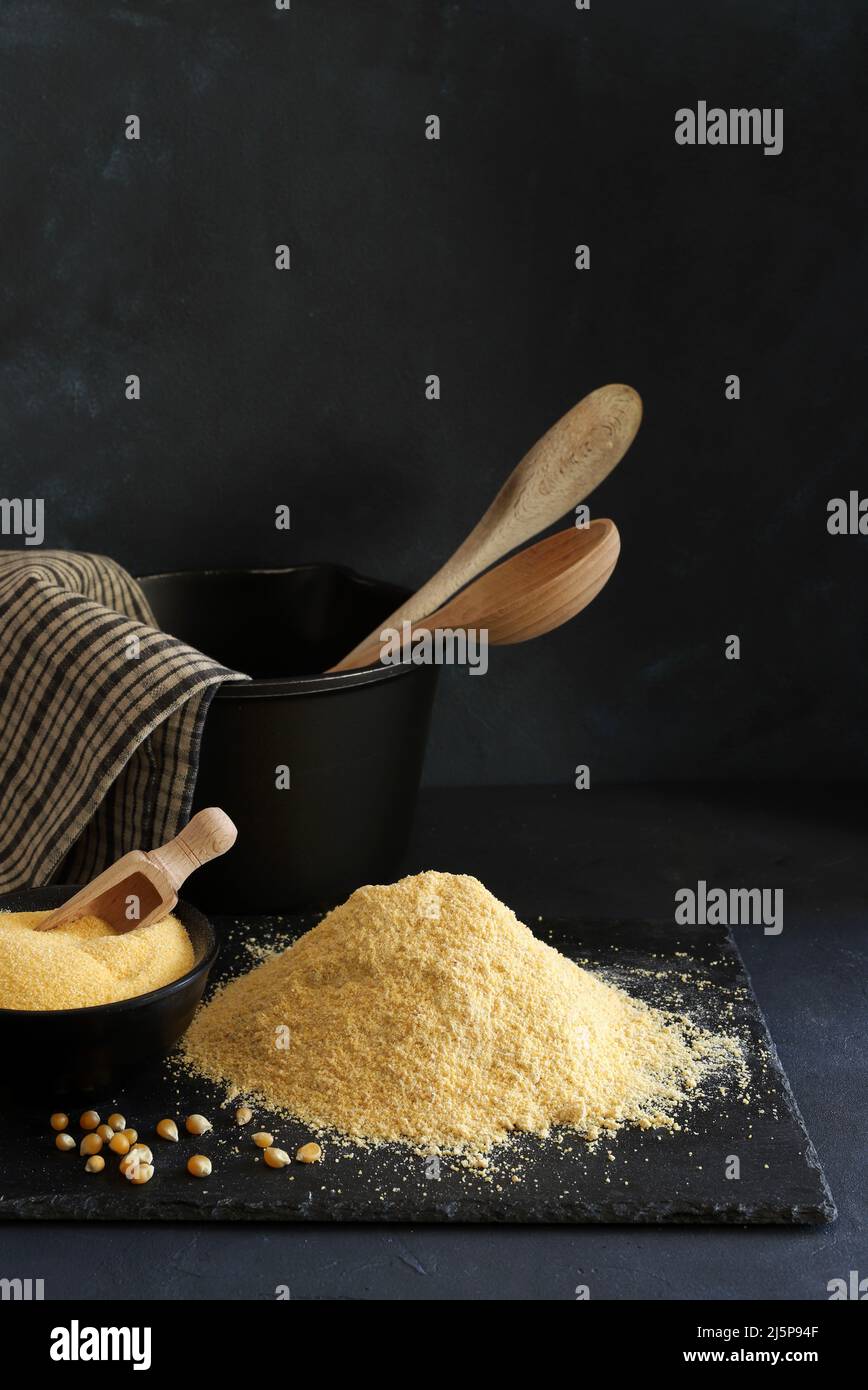 Cornmeal and corn kernels on a black background. Stock Photo