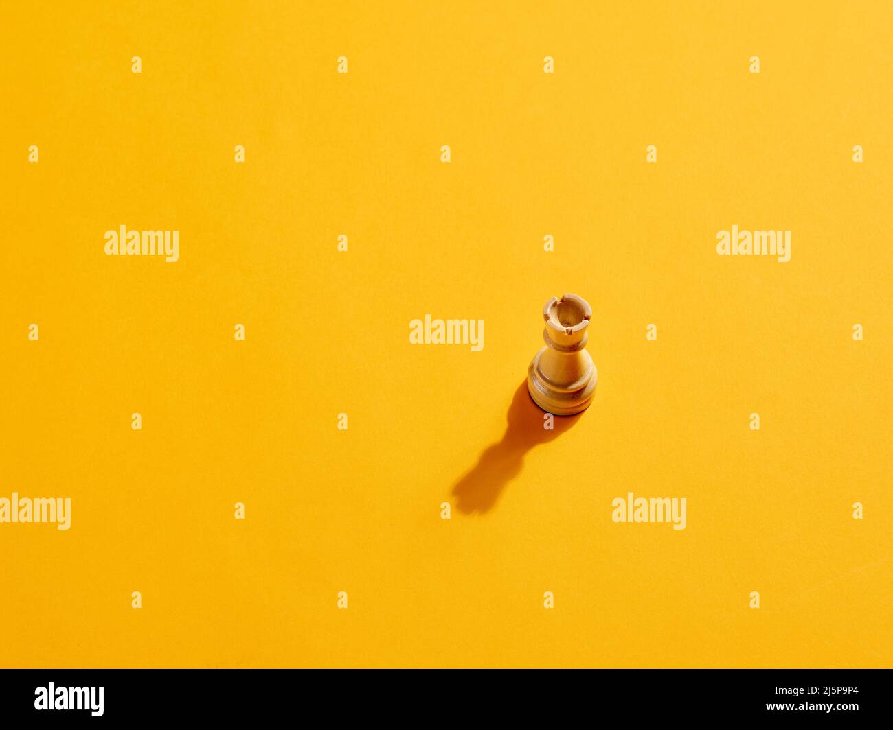 Rook or castle chess piece on yellow background with copy space. Stock Photo
