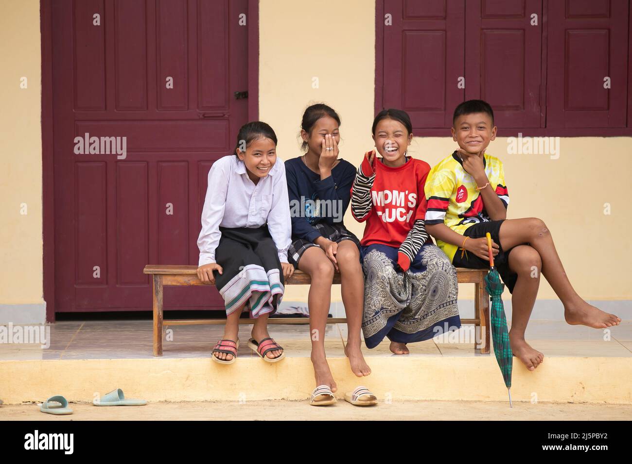 Luang Prabang, Laos. 22nd Apr, 2022. Lao pupils sit in front of a new house at the China-aided railway relocation settlement in Buam Aor Village, Xiang Ngeun District, Luang Prabang Province, Laos, April 22, 2022. The Lao villagers resettled for the construction of the China-Laos Railway are moving into new houses built with China's aid.TO GO WITH 'Feature: Railway-resettled villagers move into new homes with new hopes' Credit: Kaikeo Saiyasane/Xinhua/Alamy Live News Stock Photo