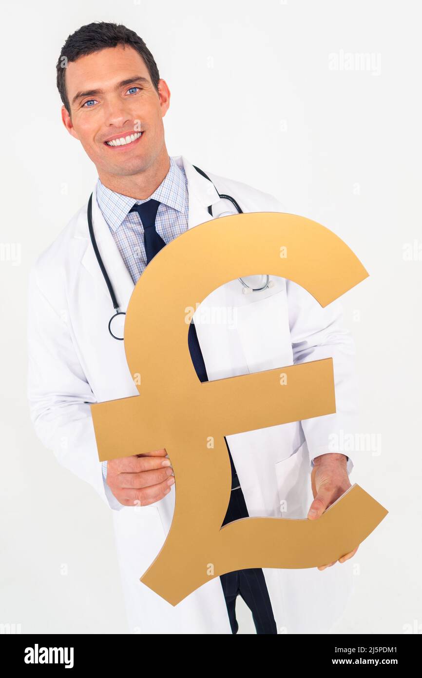 Happy smiling male doctor holding British Pound sign. Cost of medical health insurance healthcare concept. Stock Photo