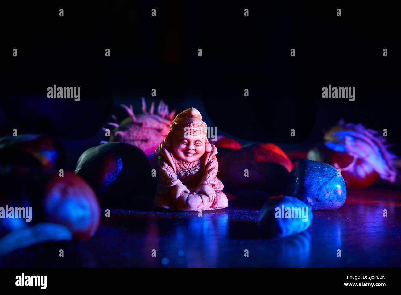 Figurine of the holy Buddha, mineral stones, chestnuts filled with blue light Stock Photo