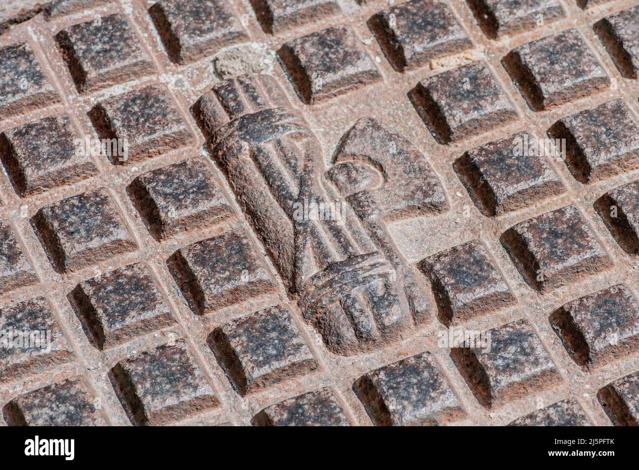Faded symbol of Fascism on a manhole of the sewer or water system, Mottola, Puglia, Italy Stock Photo