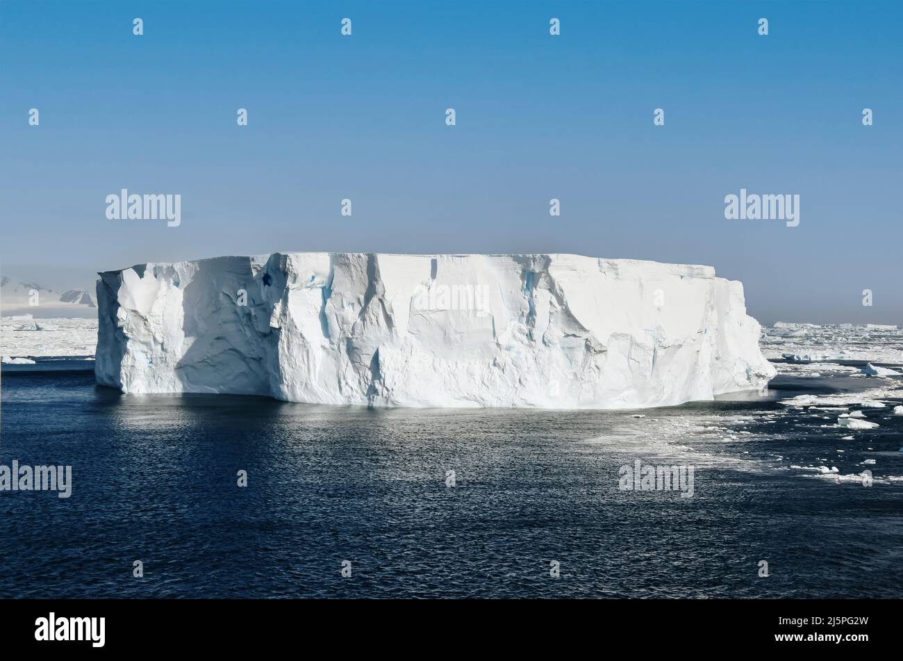 large iceberg near antarctic peninsula against blue sky Stock Photo